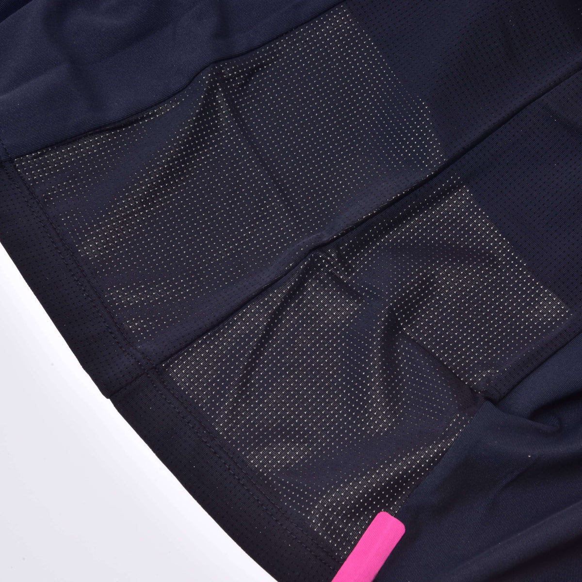 Close-up of the T-Shirt LarDen Active Black by Hobby Horse LarDen, showing black spandex fabric with mesh ventilation panels and perforations for breathability; a pink tag is partially visible at the bottom right.
