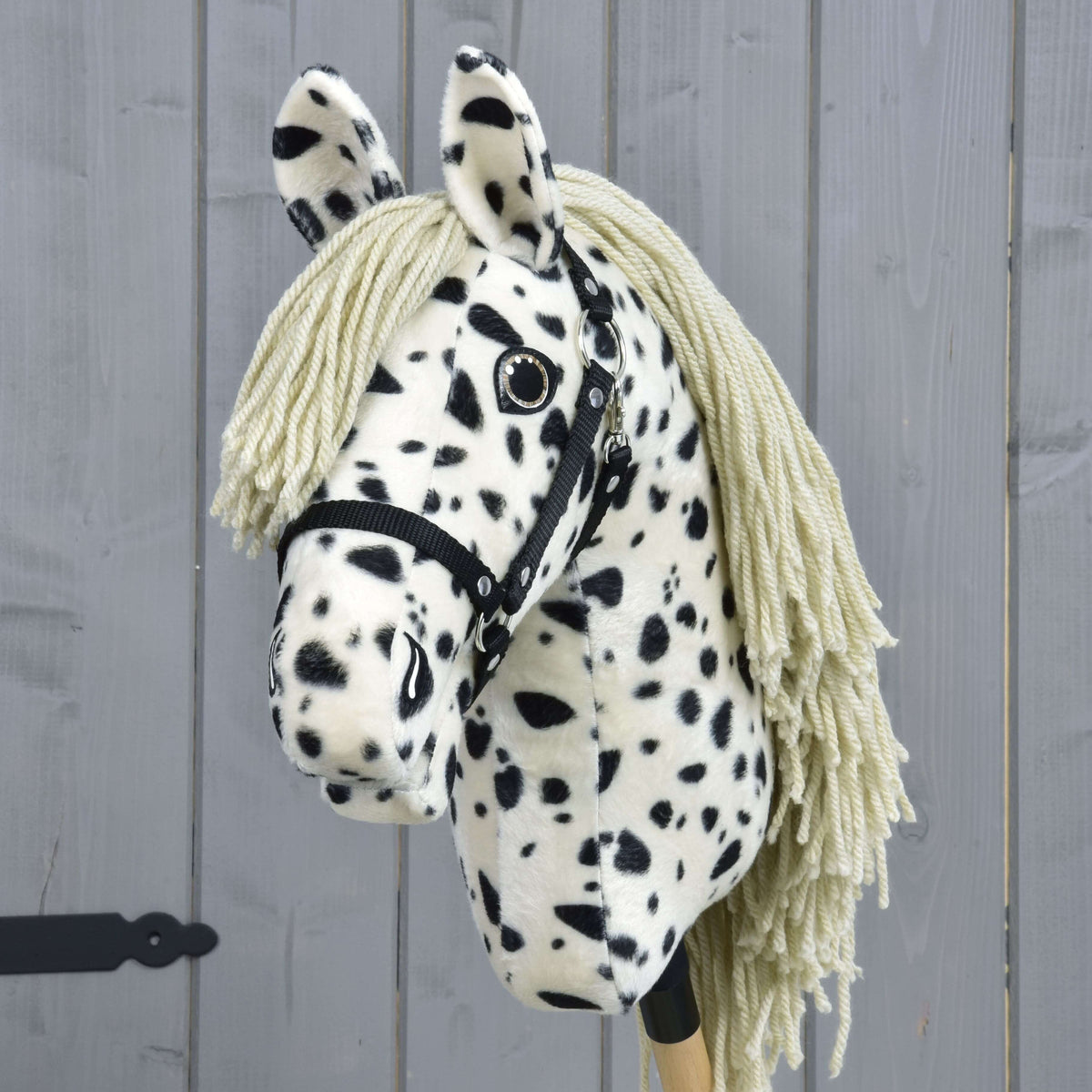 The Hobby Horse LarDen "Lord Valentine" features a black and white spotted coat, yarn mane, and a black halter, set against a gray wooden background.