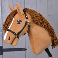 The Hobby Horse LarDen "Hobby Horse Wendy with Black Halter" is a chestnut mare plush toy featuring a brown yarn mane, white face stripe, and black halter—ideal for imaginative play—shown against a wooden panel background.