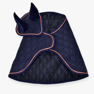 The Set Winner ear bonnet by Hobby Horse LarDen is a quilted navy blue design with orange trim, two upright ear covers, and a curved fit—perfect for stylishly covering your horse’s ears and part of its head.
