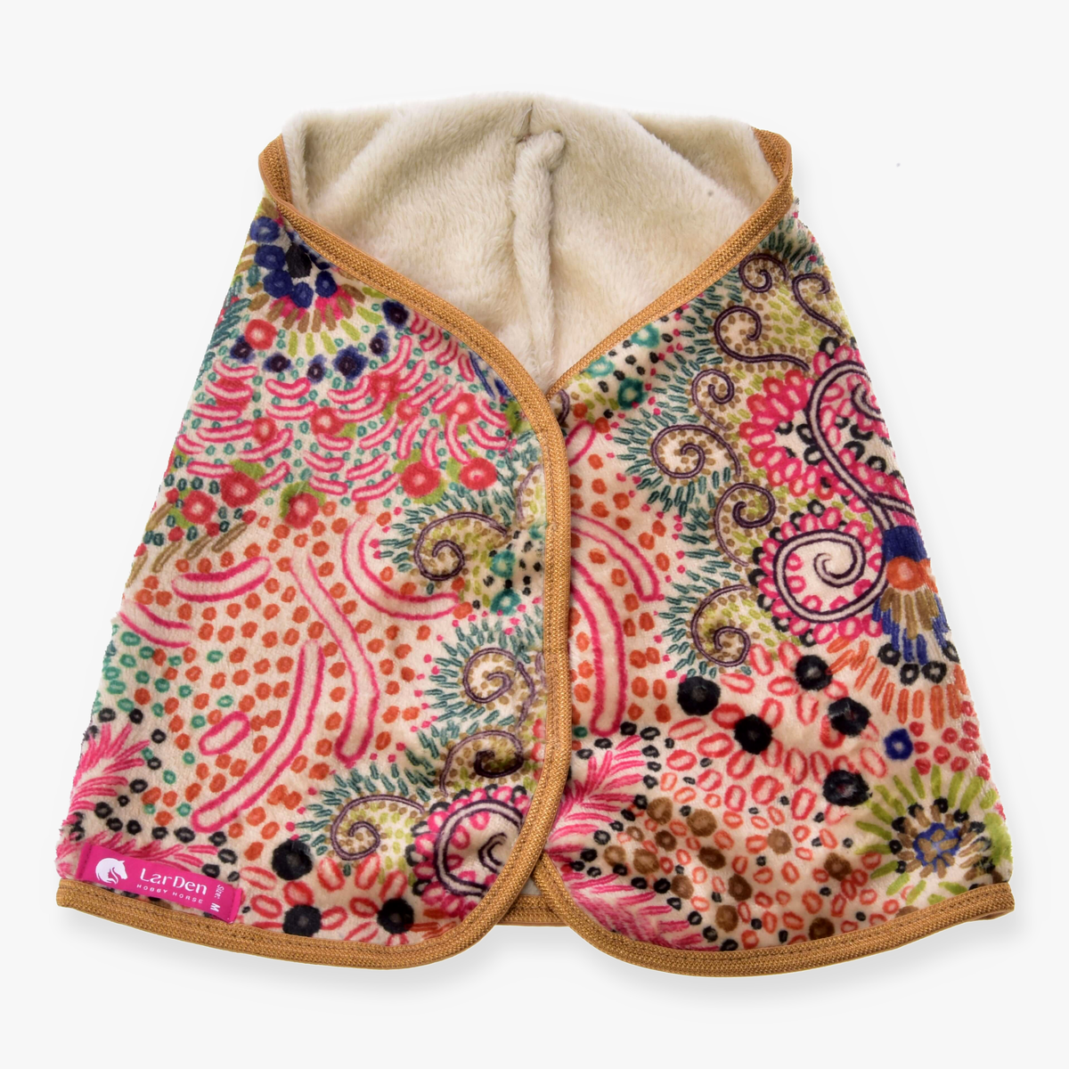 The Blanket Jungle by Hobby Horse LarDen is a vibrant patterned cape with a soft cream lining, tan trim, and pink, green, blue, and orange floral and dot designs. A pink LarDen label appears on the lower left corner.