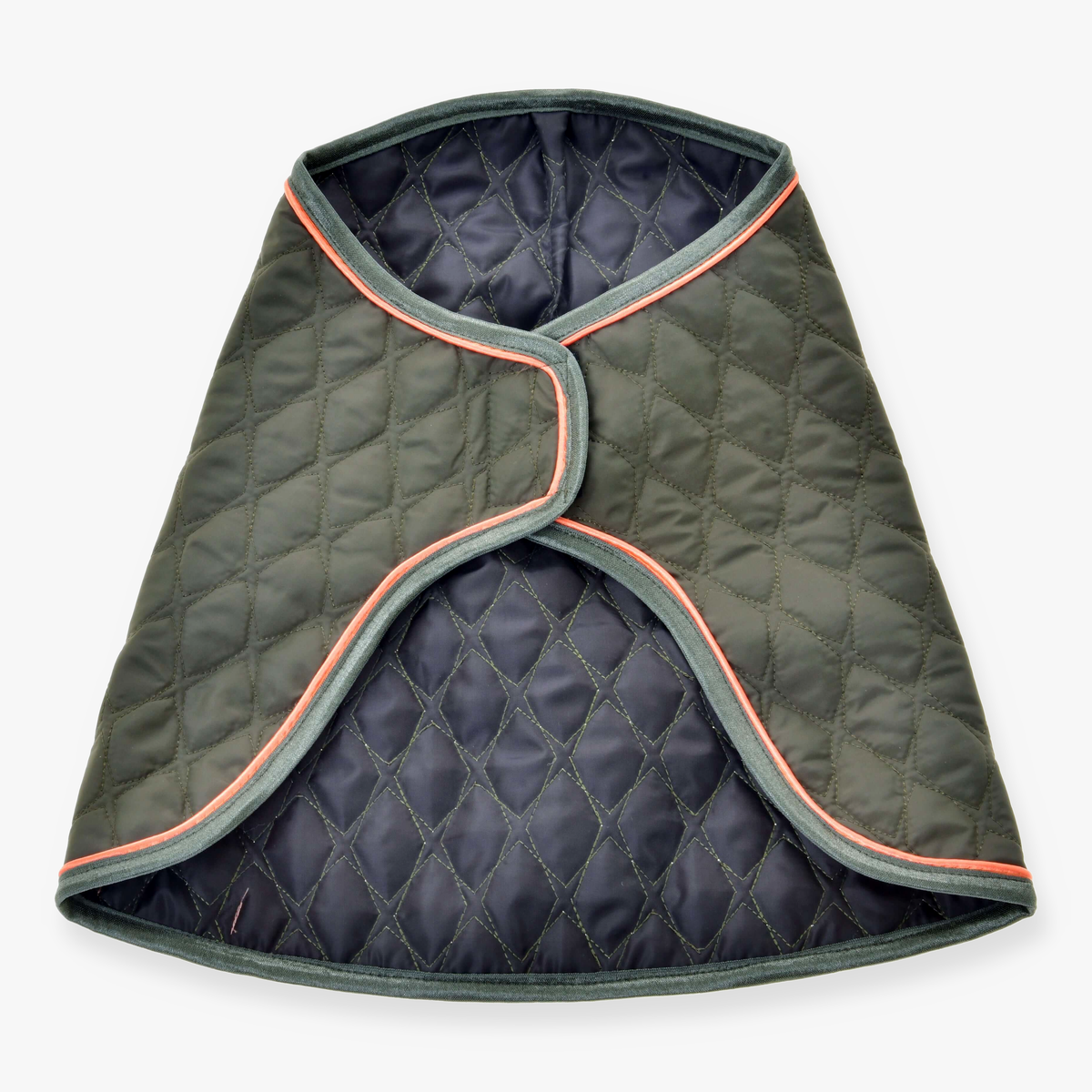 The Blanket Sport by Hobby Horse LarDen is a quilted, dark green dog coat with grey trim and light orange piping, inspired by protective horse blankets. Shown open and flat, it displays a diamond-stitched pattern and curved edges.