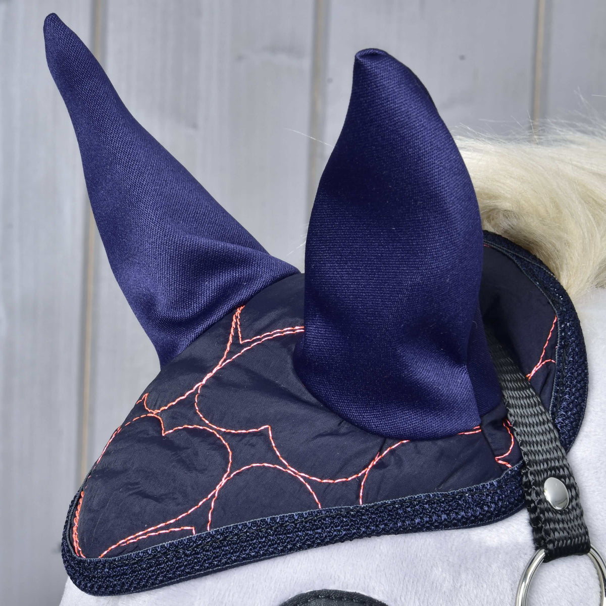 Close-up of the Ear Bonnet Pink Heart on a grey Hobby Horse: navy ears and pink heart quilting above the black halter