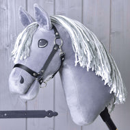 The Hobby Horse LarDen Calypso with Black Halter, inspired by the Dutch Warmblood, features a gray coat and white yarn mane, shown on a stick in front of a light gray wooden wall.