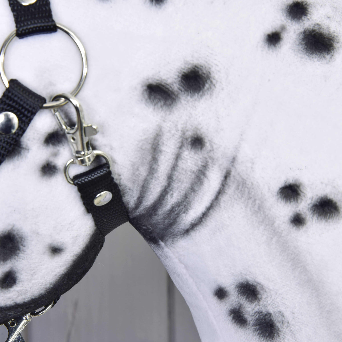 Close-up of the Hobby Horse Chantal by LarDen, featuring a white neck with black spots and a black halter with silver rings and buckles. The unique hand-crafted fur pattern highlights this stunning mare.