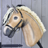 The Hobby Horse LarDen Colby features a tan body, cream-and-black yarn mane, and black halter, shown against a light gray wooden background.
