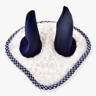 A close-up of the Hobby Horse LarDen Ear Bonnet Cube Blue, featuring soft navy ear-like protrusions on a white fuzzy base with black and white checkered trim for stylish horse insect protection.