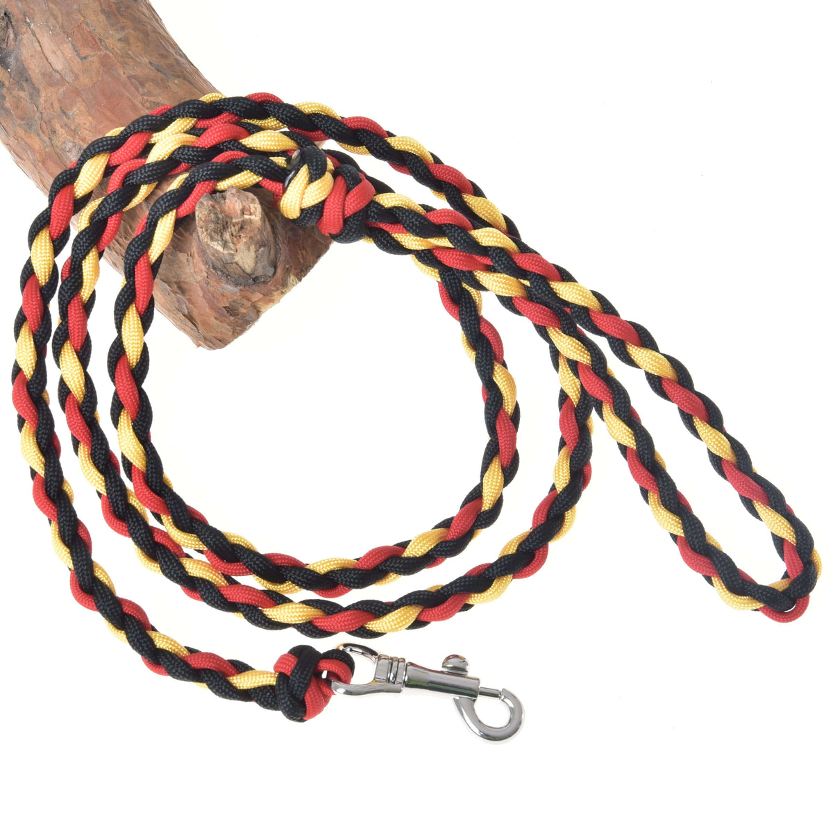 The Hobby Horse LarDen Hobby Horse - rope stripe Flag is a braided leash with black, red, and yellow strands, a durable metal clasp, and is neatly coiled on light wood—perfect for dogs or hobby horse play.