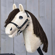 The Hobby Horse LarDen Frederik LD features a beige face, black halter, and long brown yarn mane, shown against a light gray wooden background.