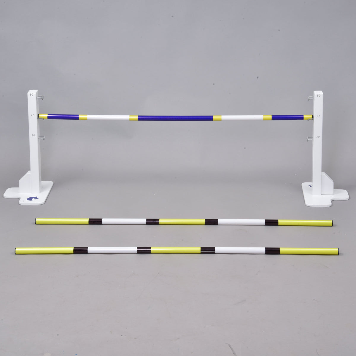 The Hobby Horse LarDen Jump 50 cm / 20 inch with Extra Poles includes three striped poles—two on the ground and one elevated—providing an adjustable obstacle for equestrian, dog agility, or Hobby Horsing training, suitable for indoor or outdoor use.