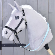 A gray plush hobby horse with a white mane and Reins rubberized Light blue by Hobby Horse LarDen, attached to a wooden stick, in front of a gray wooden wall.
