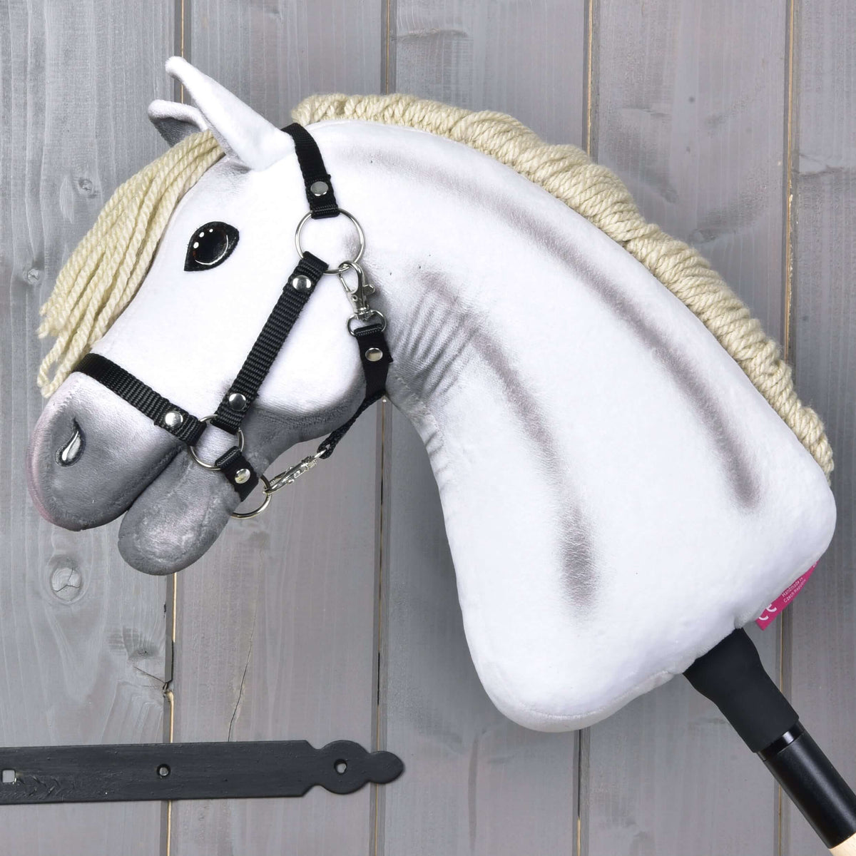 The Hobby Horse LarDen Little Lady features a white plush head with black halter and cream mane, mounted on a black stick—ideal for imaginative play.