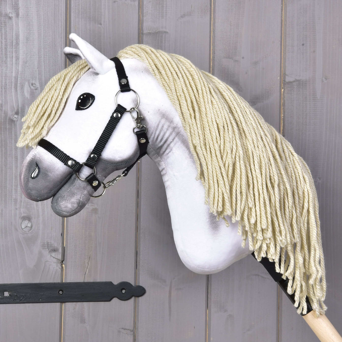 The Hobby Horse LarDen Little Lady with Black Halter features a white plush head, thick blonde yarn mane, and black halter on a wooden stick—perfect for imaginative play or dressage practice.