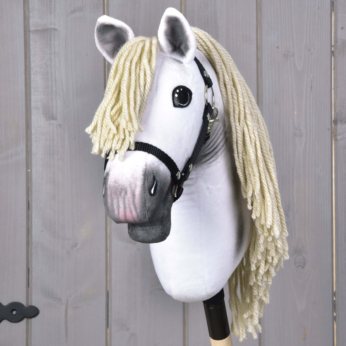 The Hobby Horse LarDen "Little Lady" features a black halter, large black eyes, and a long light blonde yarn mane on a stick—perfect for imaginative dressage play against a light wood background.