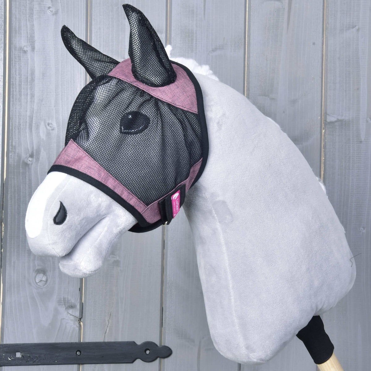Hobby Horse fluemaske De Luxe lyserød fra LarDen på en grå kæphest: sort net med gammelrosa bånd og ører af net