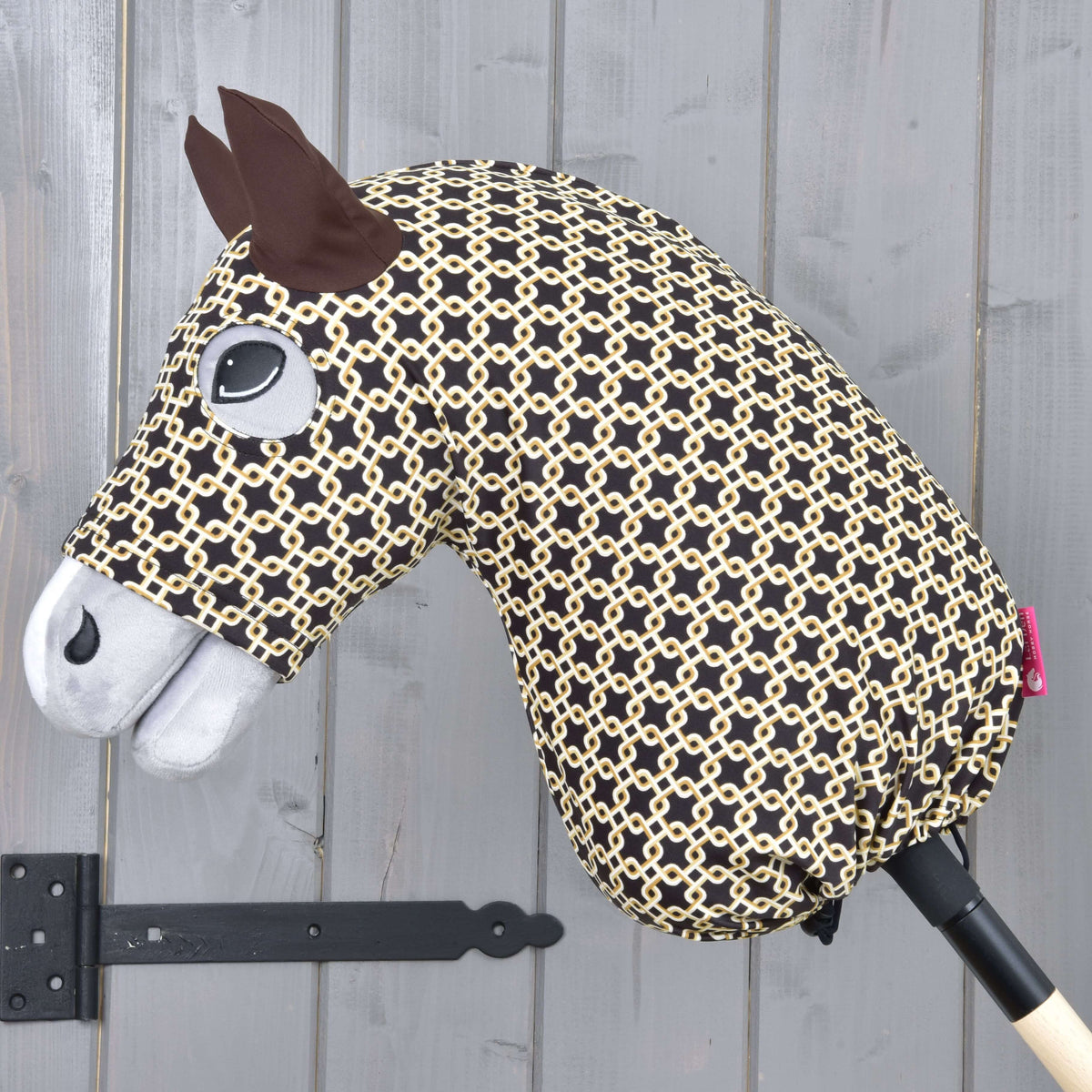 Hobby Horse beskyttelsesdragt Luxus Design fra LarDen, mørkebrun med cremefarvet kædemønster, på en grå kæphest
