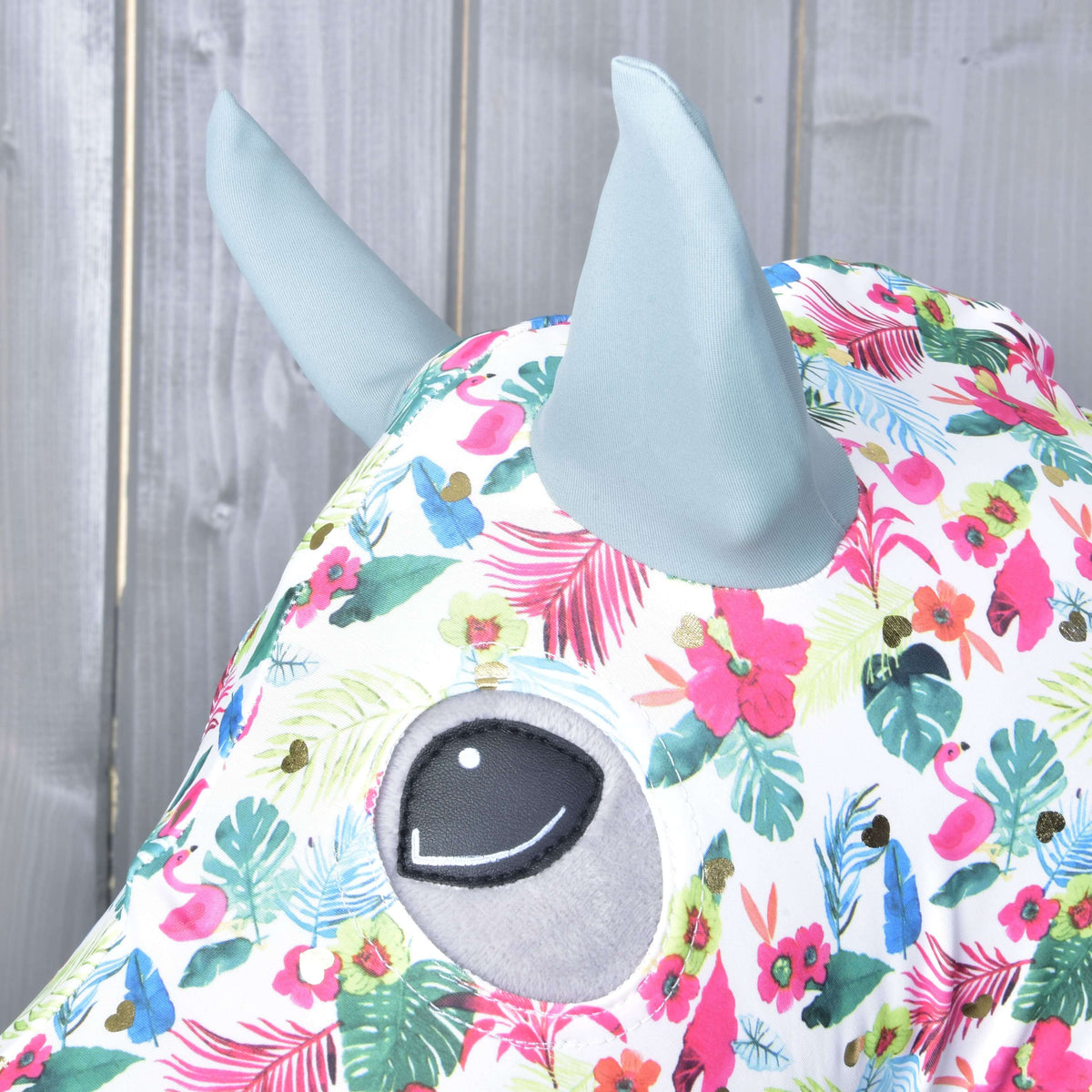 Close-up of the sage ears and eye opening on the white Lycra suit with pink flowers, flamingos and gold hearts