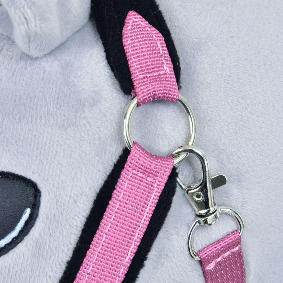 Close-up of the Hobby Horse LarDen Fur Halter LarDen Pink, showing a plush toy's light gray surface, shiny metal ring on the pink fur halter strap, silver clasp, and part of a black and pink ear with a black eye.