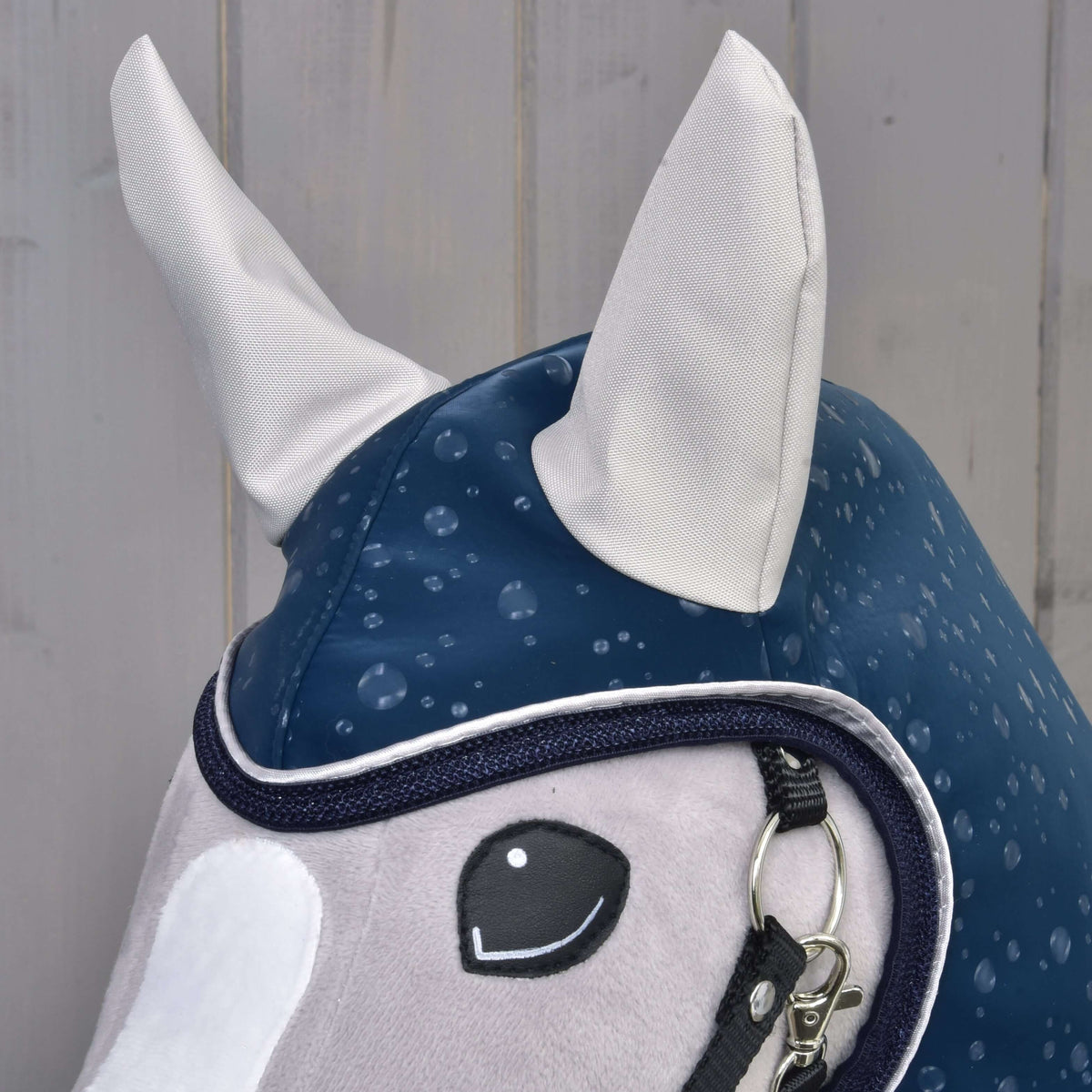 Detalje af hætten på regndækkenet Derby til Hobby Horse med lysegrå ører og marineblå og hvid kant