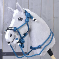 The Rope set Chess by Hobby Horse LarDen is a plush hobby horse with a gray face, white blaze, and blue halter reins cordeo with black and white accents, displayed against a wooden wall background.