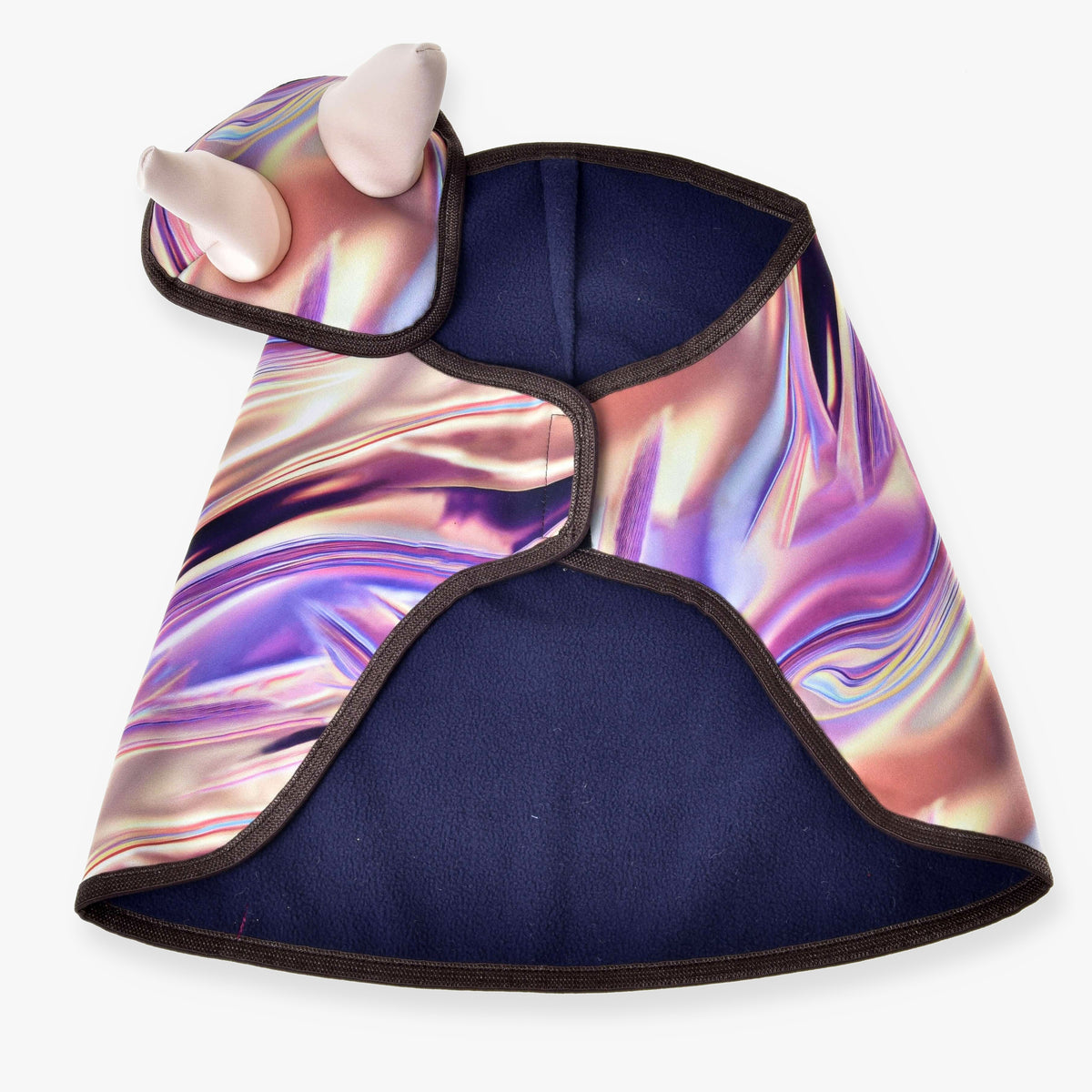 The Set Valery fleece pet cape by Hobby Horse LarDen features an abstract iridescent pattern, black trim, and a hood with two soft white horns. Inspired by a playful blanket set, the cape is shown laid flat to display its colorful design.