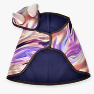The Set Valery fleece pet cape by Hobby Horse LarDen features an abstract iridescent pattern, black trim, and a hood with two soft white horns. Inspired by a playful blanket set, the cape is shown laid flat to display its colorful design.