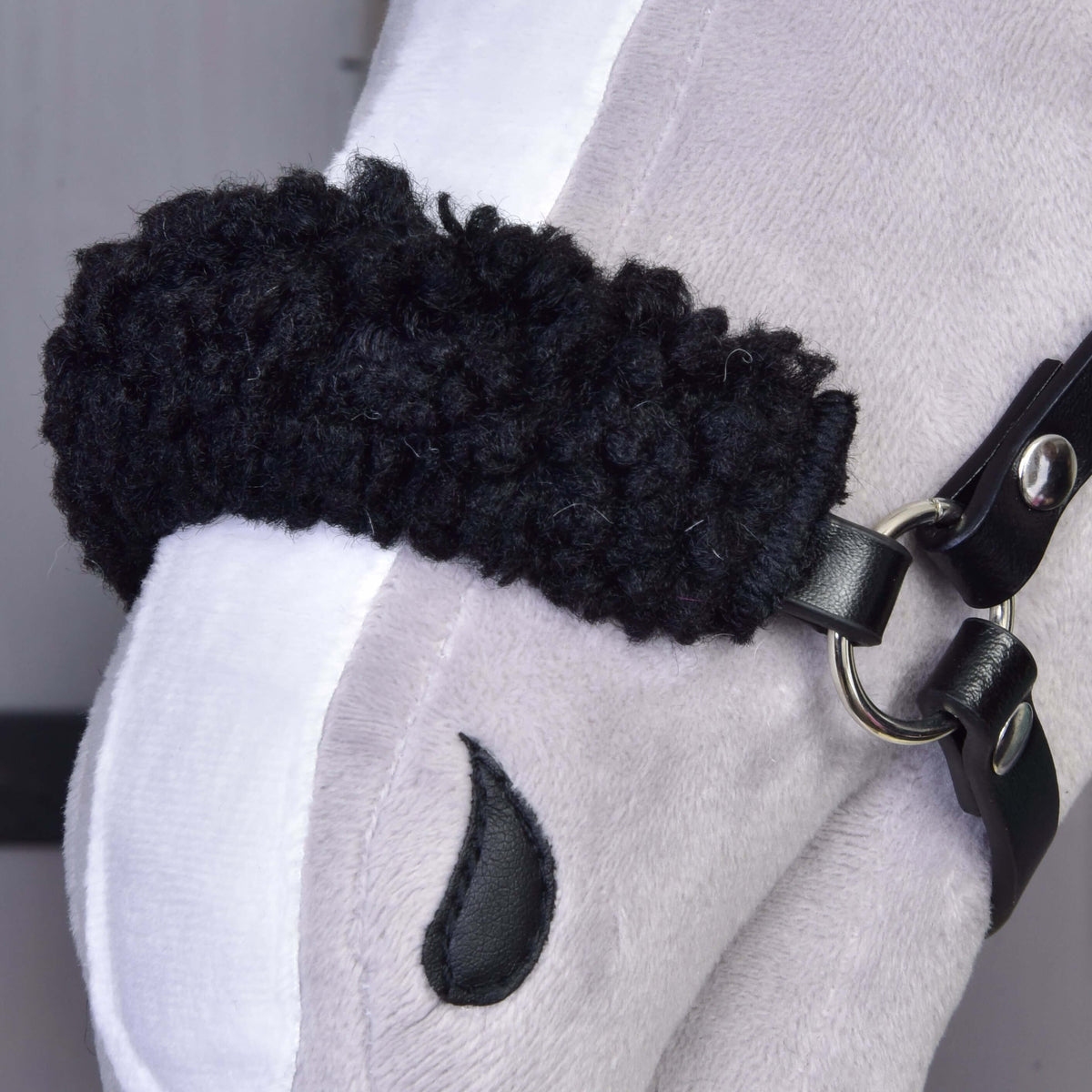 A close-up of the Set Harmony Green Hobby Horse LarDen plush shows its soft face with a white nose stripe, black bridle, embroidered nostril, and fuzzy textured black noseband.
