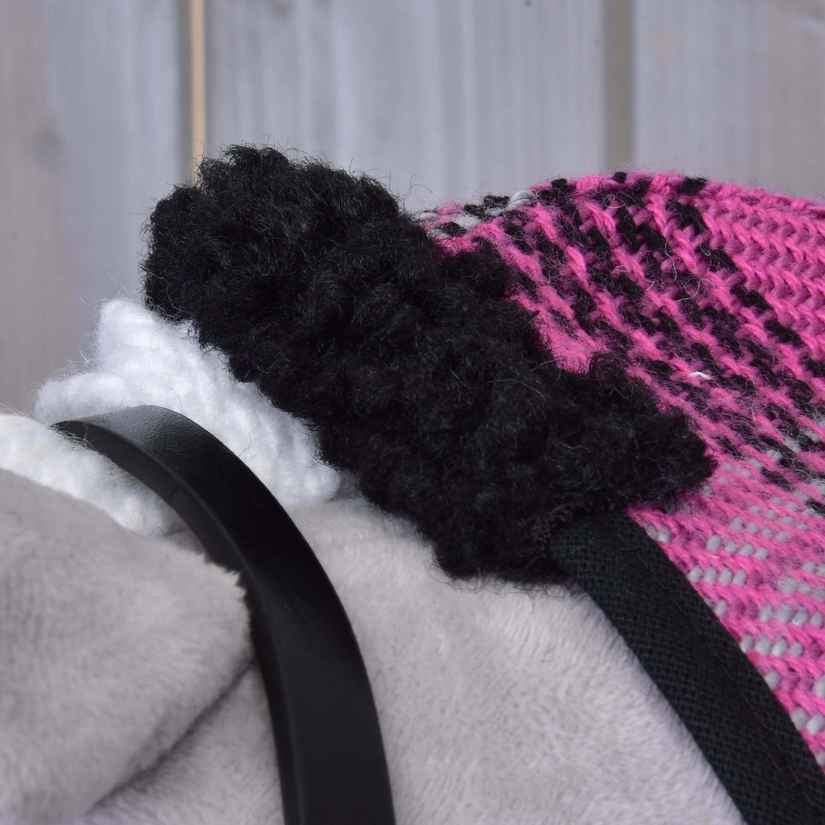 Close-up of the Set Harmony Pink by Hobby Horse LarDen: features pink and black knit fabric with a fuzzy black edge, white textured detail, and a smooth black halter strap, all set on a light gray background.