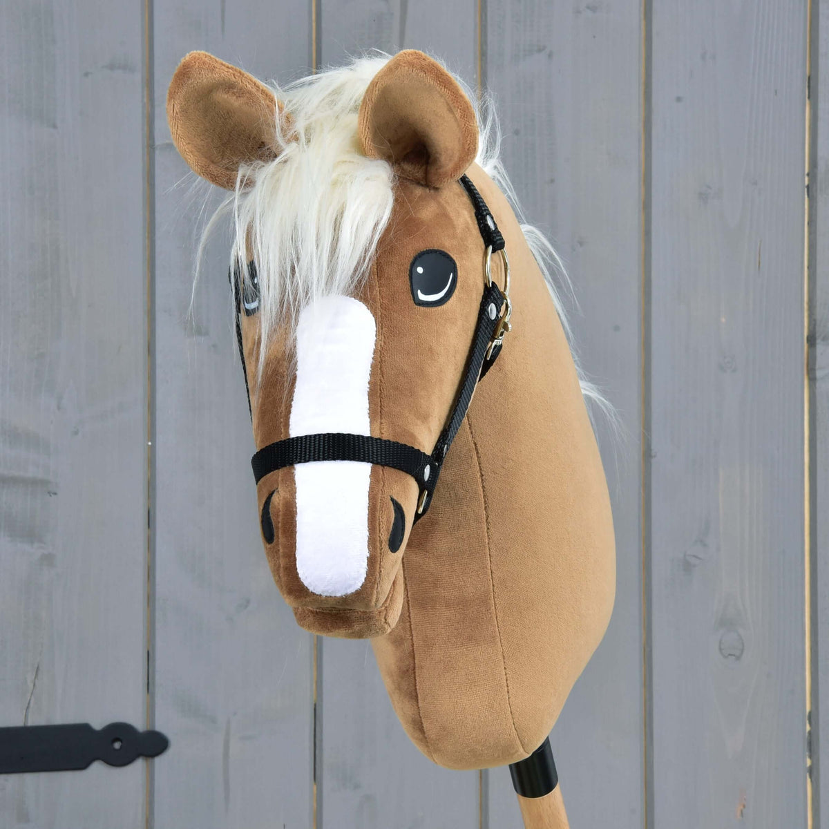 The Hobby Horse LarDen "Hobby Horse Star" features a caramel coat, white blaze, cream mane, and comes with a black halter, shown against a gray wooden background.