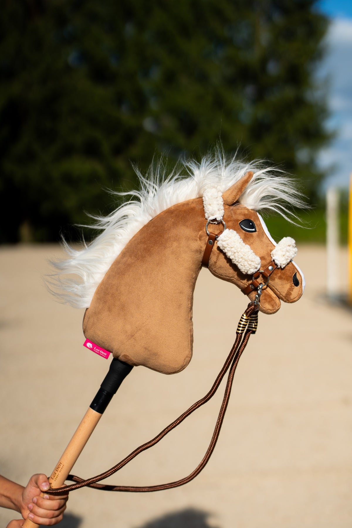Hobby Horse Reins Vivaldi, brown rope reins on a tan Hobby Horse with a white mane outdoors