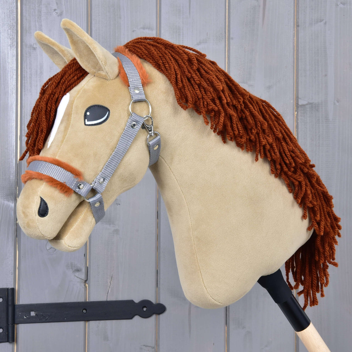 Hobby Horse LarDen’s "Hobby Horse Oliver with Black Halter + Fur Halter for FREE" features a beige felt head, brown yarn mane, grey bridle, and wooden stick handle, capturing the essence of an Oldenburg stallion.