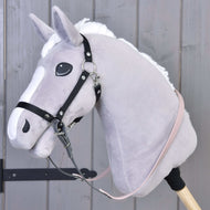 A close-up of a Hobby Horse LarDen with a light gray head, white mane, and Reins rubberized Dark Grey/Pink, attached to a cream-colored stick against a wooden background.