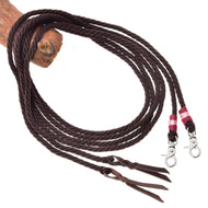 The Hobby Horse LarDen Split Western Reins Kansas are dark brown reins looped around a wooden rod, featuring snap hooks with pink and white thread accents on one end and leather poppers on the other.