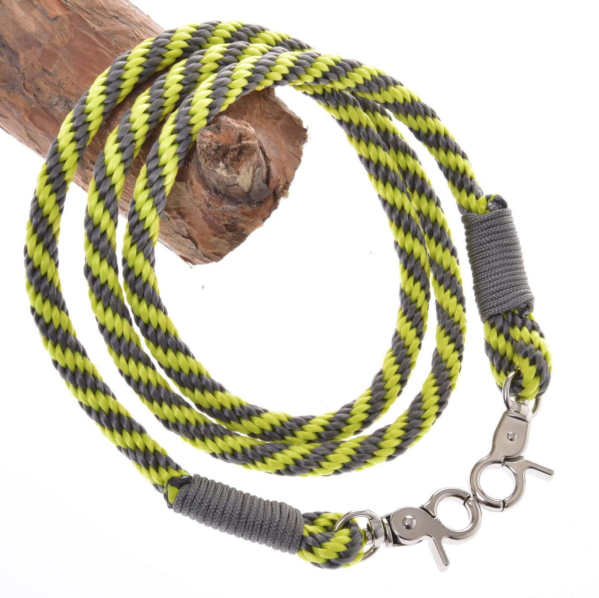 The Rope set Lime (size M) by Hobby Horse LarDen—a handmade yellow, black, and gray striped braided rope leash with metal clasps—is coiled on a wooden branch against a white background.