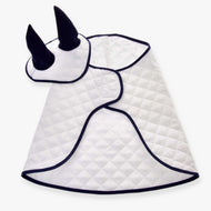 The Set Thermo White from Hobby Horse LarDen includes a white quilted blanket with dark trim, cloak-shaped, and a matching ear bonnet with two upright black horns.