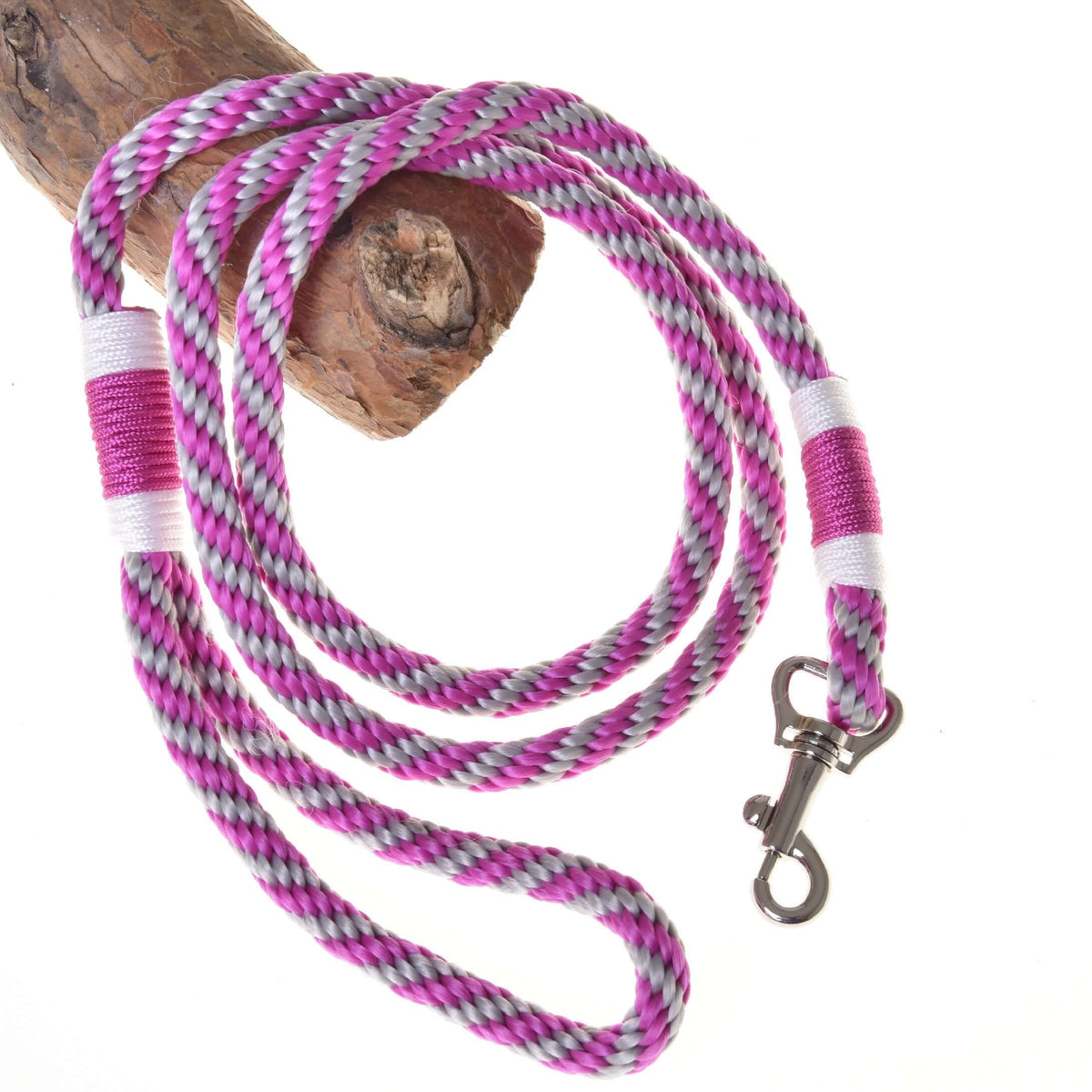 The Hobby Horse LarDen Lead rope stripe pink features pink, white, purple, and black braids with a metal clasp, coiled on wood against a white background.